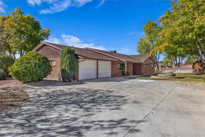 Ranch-style house featuring brick siding, driveway, and a garage