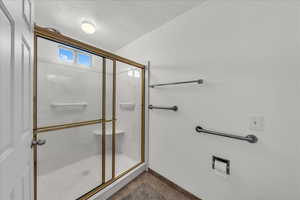Full bath with a textured ceiling, a marble finish shower, and tile patterned floors