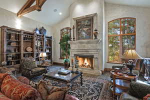 Living room with hardwood / wood-style floors, a high end fireplace, high vaulted ceiling, and recessed lighting
