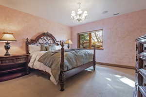 Bedroom with a chandelier and carpet floors