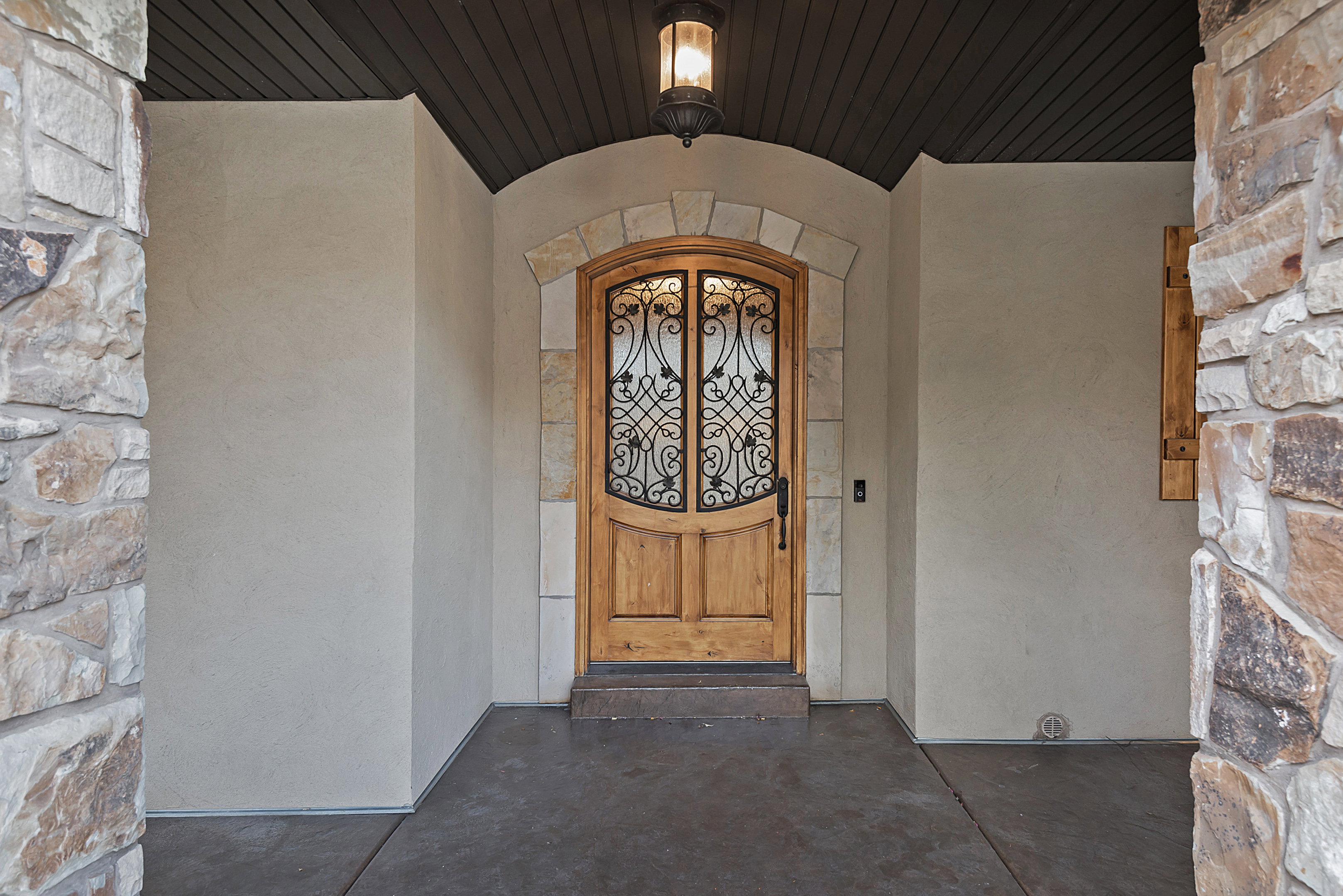 Doorway to property with stone siding and stucco siding