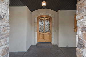 Doorway to property with stone siding and stucco siding