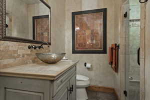 Full bath with vanity, a stall shower, and dark tile patterned floors