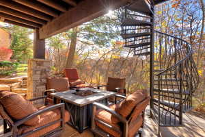 Wooden deck with stairs, a patio, and view of scattered trees