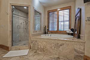 Bathroom with a bath, a shower stall, and tile patterned floors