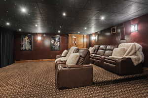 Carpeted home theater with baseboards