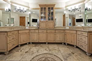 Full bathroom with a chandelier, double vanity, and backsplash