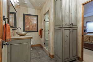 Ensuite bathroom featuring vanity, a shower stall, and a textured ceiling