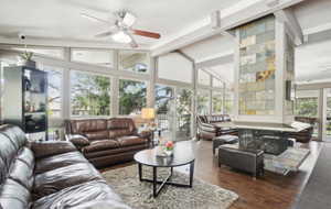 Living room with ceiling fan and dark wood-style flooring