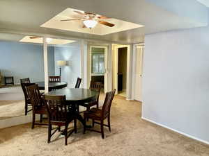 Dining space featuring light carpet and a ceiling fan