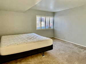 Bedroom featuring carpet flooring and baseboards