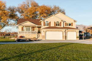View of front of home with covered porch, concrete driveway, a garage, a front lawn, and a mountain view