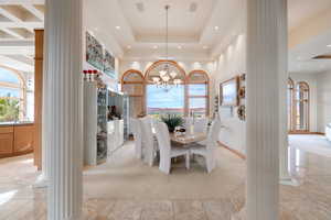 Dining space with ornate columns, a towering ceiling, healthy amount of natural light, light carpet, and recessed lighting