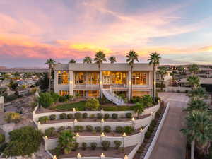 Rear view of house with stairs, a fenced front yard, and stucco siding