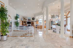Foyer with ornate columns, recessed lighting, and a chandelier