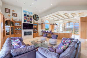 Living room with recessed lighting, a fireplace, plenty of natural light, coffered ceiling, and a towering ceiling