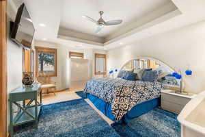 Bedroom featuring a ceiling fan, a tray ceiling, carpet flooring, and recessed lighting