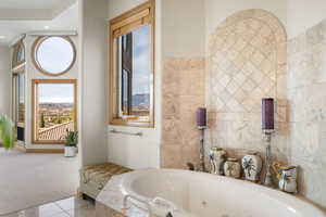 Bathroom with a tub with jets, tile walls, carpet, and tile patterned floors