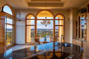 Dining room with healthy amount of natural light, a chandelier, a mountain view, and a raised ceiling