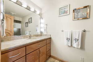 Bathroom featuring vanity, light tile patterned floors, and a textured ceiling