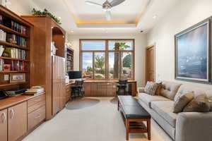 Office with built in study area, a ceiling fan, light colored carpet, a raised ceiling, and recessed lighting