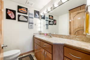 Half bath featuring vanity and baseboards