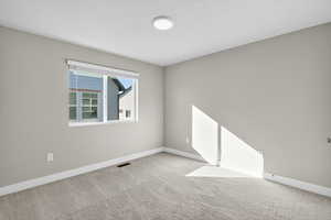 Empty room featuring carpet floors and baseboards
