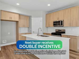 Kitchen featuring decorative backsplash, light stone counters, modern cabinets, light brown cabinetry, and recessed lighting