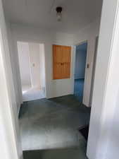 Hall featuring dark colored carpet