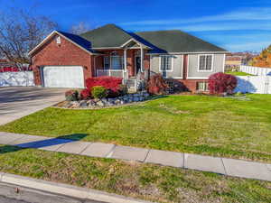 View of front of home with a porch, brick siding, driveway, roof with shingles, and a garage