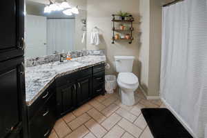 Full bathroom with vanity, a shower with curtain, and light tile patterned floors