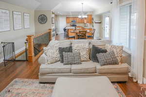 Living area with dark wood finished floors, a chandelier, and recessed lighting