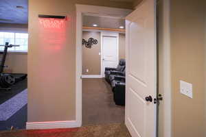 Hallway featuring dark carpet and baseboards