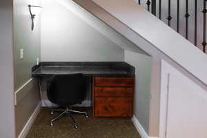 Carpeted office space with baseboards and built in study area