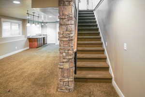 Staircase with carpet flooring, a textured ceiling, and recessed lighting