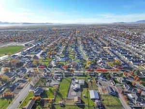Aerial view of property and surrounding area with nearby suburban area and a mountainous background