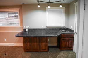 Bar area featuring dark countertops and pendant lighting