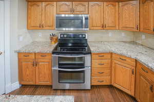 Kitchen featuring appliances with stainless steel finishes, tasteful backsplash, and brown cabinets