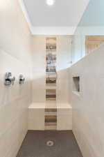Bathroom featuring a tile shower and tile walls
