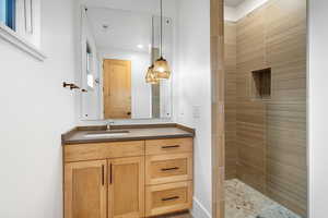 Full bath with vanity and tiled shower
