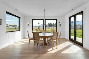 Dining area featuring a chandelier, light wood-type flooring, healthy amount of natural light, recessed lighting, and french doors