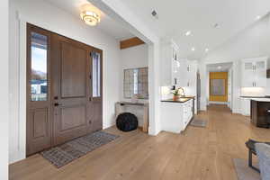 Entrance foyer with light wood-style floors, recessed lighting, and high vaulted ceiling