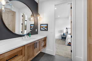 Ensuite bathroom featuring vanity, dark colored carpet, recessed lighting, and dark tile patterned flooring