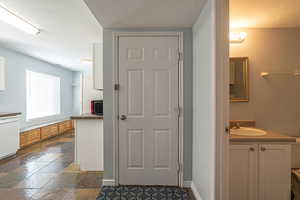 Bathroom featuring vanity, stone tile flooring, and a textured ceiling