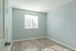 Spare room featuring wood finished floors and baseboards