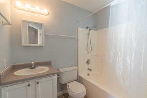 Bathroom featuring shower / bathtub combination with curtain and vanity