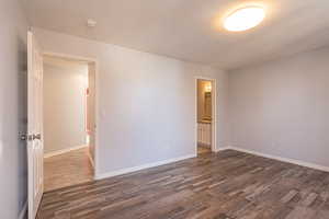 Unfurnished room featuring a textured ceiling and dark wood-type flooring