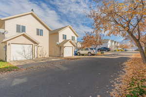 Traditional home featuring a residential view, driveway, and an attached garage