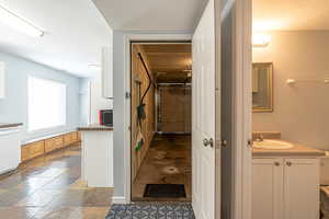 Bathroom with vanity, stone tile floors, and a textured ceiling