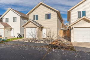 Traditional home featuring concrete driveway, a garage, and a gate